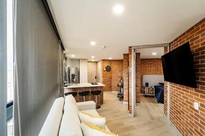 a living room with a white couch and a brick wall at Apartamento ubicado en, LAURELES, MEDELLIN in Cartagena de Indias