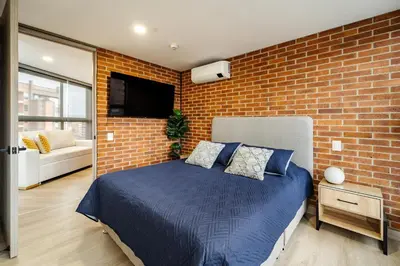 a bedroom with a bed and a brick wall at Apartamento ubicado en, LAURELES, MEDELLIN in Cartagena de Indias