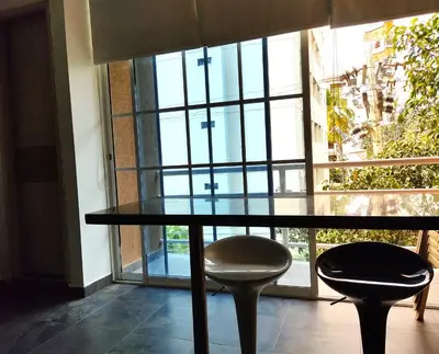 a glass table and two stools in front of a window at SGH Hotel Palm Bay Bello Horizonte in Santa Marta