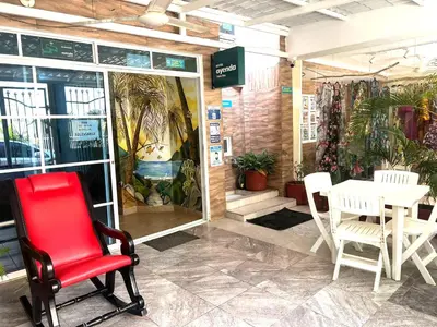 a red chair in front of a table in a store at SGH Hotel Palm Bay Bello Horizonte in Santa Marta