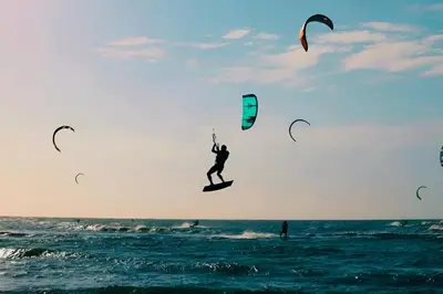 a person riding a surfboard on the ocean with kites at AzulRest Casa de Verano in Santa Veronica