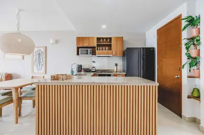 a kitchen with a large wooden island in the middle at Frente Al Mar Ciudad Antigua Home Office 14B in Cartagena de Indias