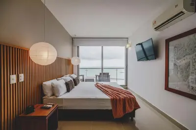a bedroom with a bed with a view of the ocean at Frente Al Mar Ciudad Antigua Home Office 14B in Cartagena de Indias