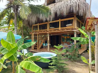 a resort building with a thatched roof at Cabañas roble verde in Rincón