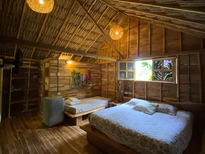 a bedroom with a bed in a wooden room at Cabañas roble verde in Rincón