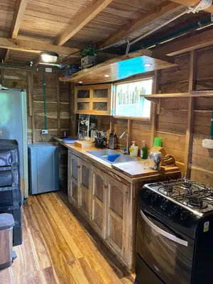 a kitchen with wooden cabinets and a stove top oven at Cabañas roble verde in Rincón