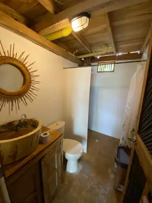 a bathroom with a sink and a toilet and a mirror at Cabañas roble verde in Rincón