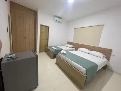 a hotel room with two beds and a desk at Hotel Mariscales Sincelejo in Sincelejo