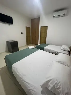 a room with two beds and a television in it at Hotel Mariscales Sincelejo in Sincelejo