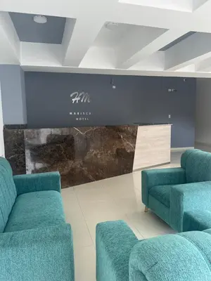 a waiting room with blue couches in front of a wall at Hotel Mariscales Sincelejo in Sincelejo