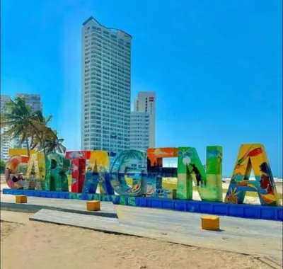 a sign on the beach with a city in the background at Apartamento con espectacular vista al oceano in Cartagena de Indias
