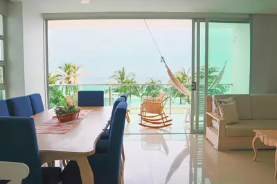 a dining room with a table and chairs and a balcony at Magico Apartamento Frente al Mar 3 Habitaciones TR21 in Coveñas