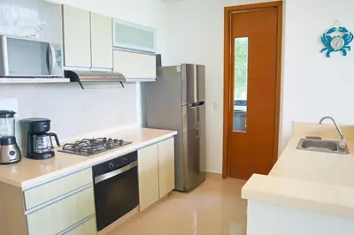 a kitchen with a stove and a refrigerator at Magico Apartamento Frente al Mar 3 Habitaciones TR21 in Coveñas