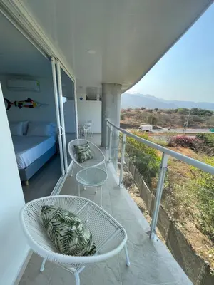 a balcony with two tables and a bed with a view at Infinity Blue - Playa Dormida in Santa Marta