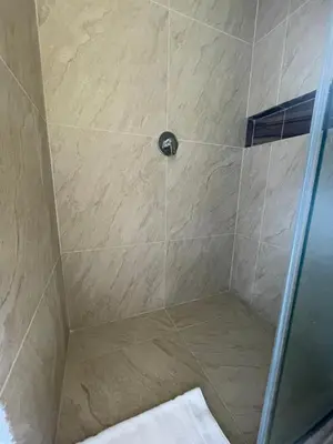 a shower with a glass door and a beige at Infinity Blue - Playa Dormida in Santa Marta