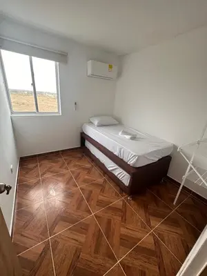 a small bedroom with a bed and a wooden floor at 