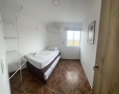 a small white room with a bed and a window at 