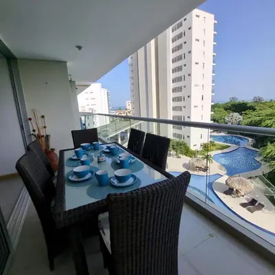a table with blue dishes on it on a balcony at Torres del Mar Santa Marta in Santa Marta