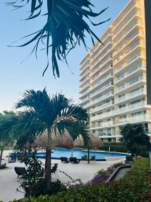 a large building with a palm tree in front of it at Torres del Mar Santa Marta in Santa Marta
