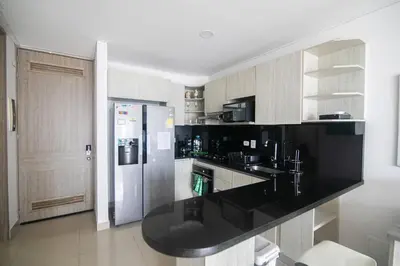 a kitchen with a black counter top and a refrigerator at Great apartment in Bocagrande with sunset & beach view in Cartagena de Indias