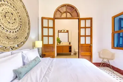a bedroom with a large white bed and a mirror at 2CM-J1 APARTAMENTO DE 2 ALCOBAS CON VISTA Y PISCINA EN GETSEMANI in Cartagena de Indias