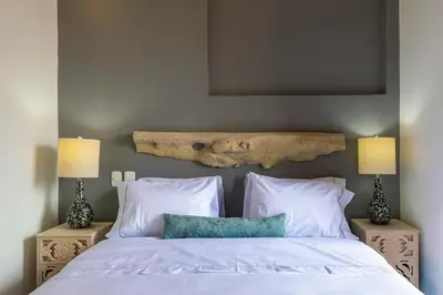 a bedroom with a bed with white sheets and two lamps at 2CM-J1 APARTAMENTO DE 2 ALCOBAS CON VISTA Y PISCINA EN GETSEMANI in Cartagena de Indias