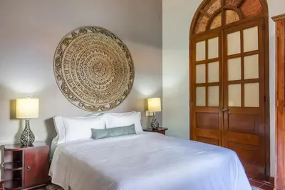 a bedroom with a white bed and a wooden door at 2CM-J1 APARTAMENTO DE 2 ALCOBAS CON VISTA Y PISCINA EN GETSEMANI in Cartagena de Indias