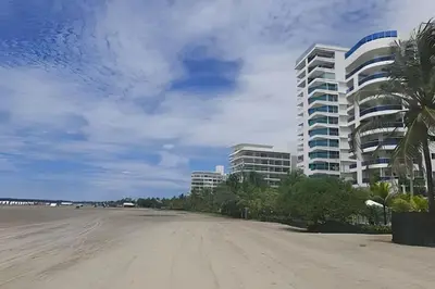 a view of a beach with a building and palm trees at 2 Dormitorios Morros. Vista Mar y salida playa in Cartagena de Indias