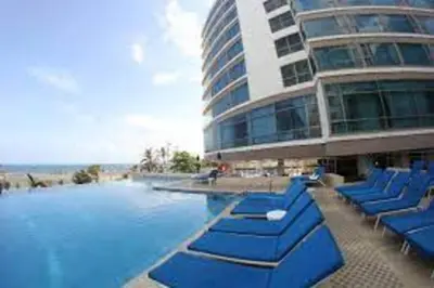a pool with blue lounge chairs in front of a building at Luxury apartment in Morros - Cartagena de Indias in Cartagena de Indias