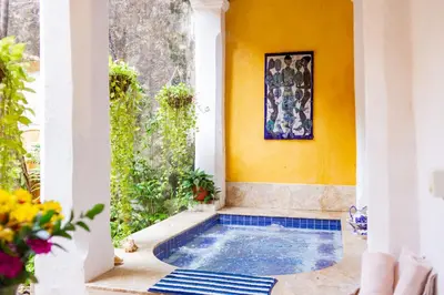 a swimming pool in a house with a yellow wall at 4CB-1 CASA COLONIAL DE 4 HABITACIONES EN EL CENTRO HISTORICO DE CARTAGENA in Cartagena de Indias
