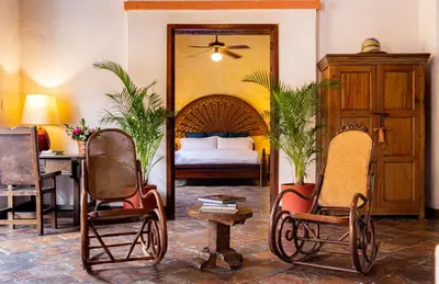 a bedroom with a bed and two chairs and a table at 4CB-1 CASA COLONIAL DE 4 HABITACIONES EN EL CENTRO HISTORICO DE CARTAGENA in Cartagena de Indias