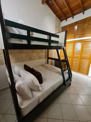 a bunk bed with white sheets and pillows in a room at Casa Blanca del Mar in Santa Marta