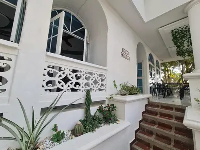 a house with white walls and stairs with plants at Casa Blanca del Mar in Santa Marta
