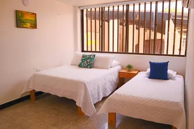 two beds in a room with a window at Hermoso Apartamento Frente al Mar 2 Habitaciones C13B in Coveñitas