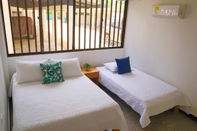 two beds in a room with a window at Hermoso Apartamento Frente al Mar 2 Habitaciones C13B in Coveñitas