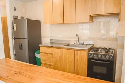 a kitchen with a sink and a refrigerator at Hermoso Apartamento Frente al Mar 2 Habitaciones C13B in Coveñitas