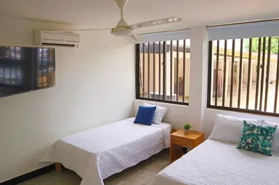 two beds in a room with two windows at Hermoso Apartamento Frente al Mar 2 Habitaciones C13B in Coveñitas