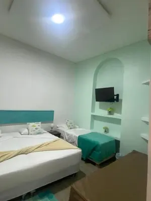 a hotel room with two beds and a tv at 4CR-1M CASA DE 4 HABITACIONES EN EL CENTRO HISTORICO, GETSEMANI in Cartagena de Indias