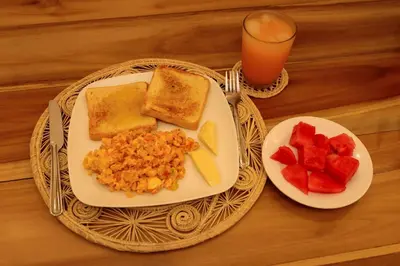 a table with a plate of breakfast food and a glass of orange juice at Hostal Casa Torres Centro Historico - Adults Only in Cartagena de Indias