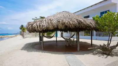 a hut on the beach with a chair under it at Cabaña Aire Viento Sol in Puerto Viejo