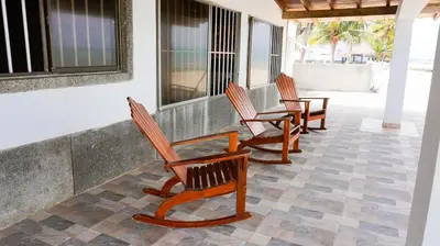 a row of chairs sitting on a porch at Cabaña Aire Viento Sol in Puerto Viejo