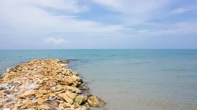 a pile of rocks in the ocean with the water at Cabaña Aire Viento Sol in Puerto Viejo