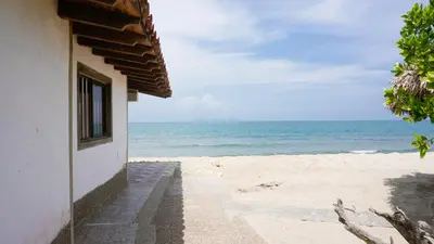 a building on the beach with a view of the ocean at Cabaña Aire Viento Sol in Puerto Viejo
