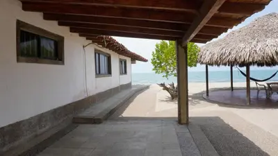 a building on the beach with a view of the ocean at Cabaña Aire Viento Sol in Puerto Viejo