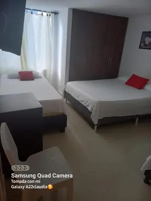 a room with two beds and a chair in it at Apartamento en cartagena in Cartagena de Indias
