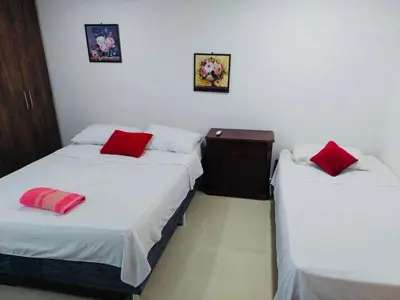 two beds in a room with red pillows on them at Apartamento en cartagena in Cartagena de Indias