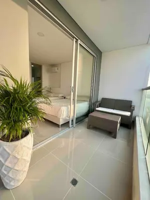 a bedroom with a bed and a couch and a plant at Apartamento Moderno y lujoso con vista al mar Piso 1903 - cerca a ciudad amurallada in Cartagena de Indias