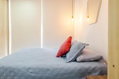 a bed with three pillows on top of it at Apartamento Moderno y lujoso con vista al mar Piso 1903 - cerca a ciudad amurallada in Cartagena de Indias