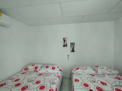 a bedroom with two beds with red and white sheets at Cabaña Isabella in San Bernardo del Viento