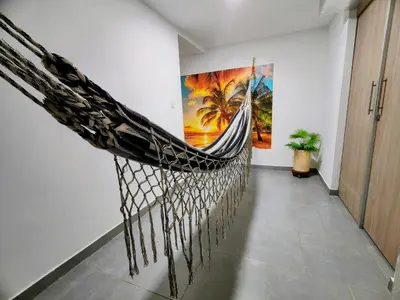 a hammock hanging on a wall in a room at Tranquilo Apartamento Central Cerca a la Playa Puerto Colombia in Puerto Colombia